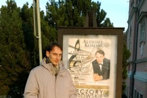 Alexey Komarov przy afiszu w koncertów w Trzebnicy autorstwa Marleny Dudek. Fot J. Adamowski.